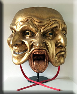 Afbeelding van een masker met drie gezichtsuitdrukkingen.